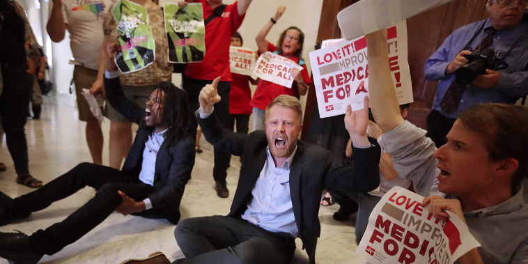 Image: Demonstrators from Texas sit on the ground and chant, \"Kill the bill, kill the bill,\" outside the offices of Sen. Ted Cruz while protesting against health care reform legislation on Capitol Hill on July 10, 2017.