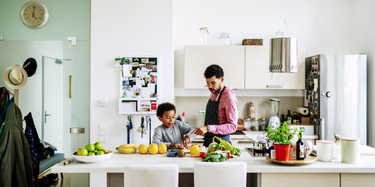 Father And Son Helping Each Other Prepare Some Lunch