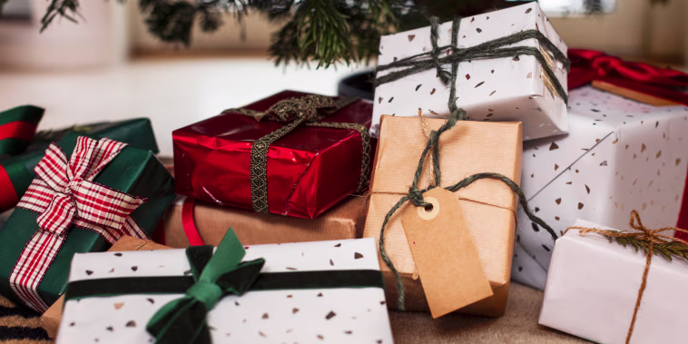 Presents sit under a Christmas tree.