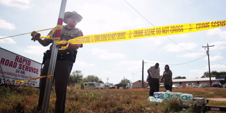 A police officer ties crime scene tape near the First Baptist Church of Sutherland Springs