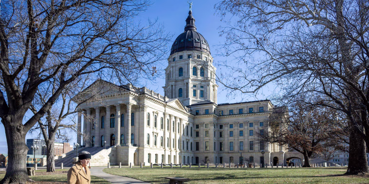 A person walks by The Kansas State Capitol outside