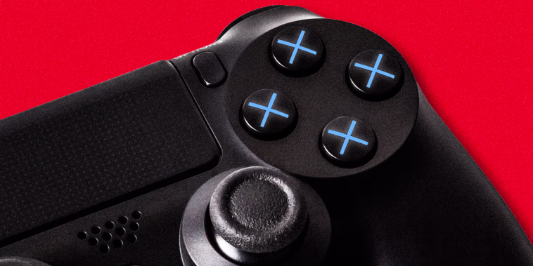 A close up of a black PlayStation controller, showing the four operational buttons with all blue X's instead of the regular four different shapes, against a red background