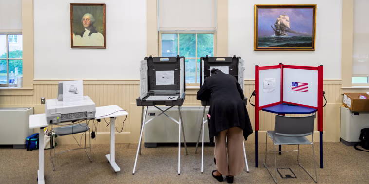 A voter casts their ballot at the Wenham Museum