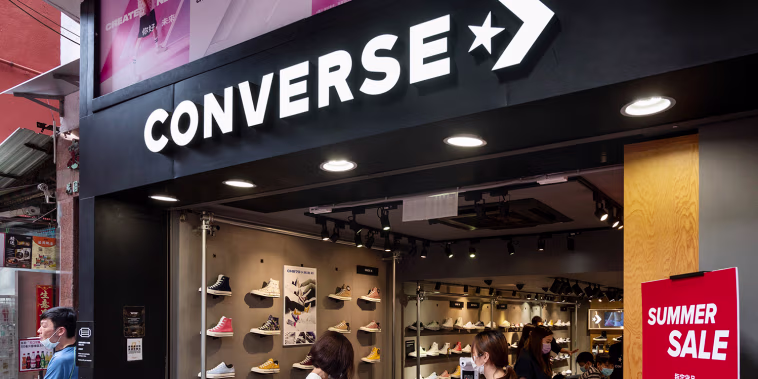 Pedestrians walk past American shoe brand company Converse
