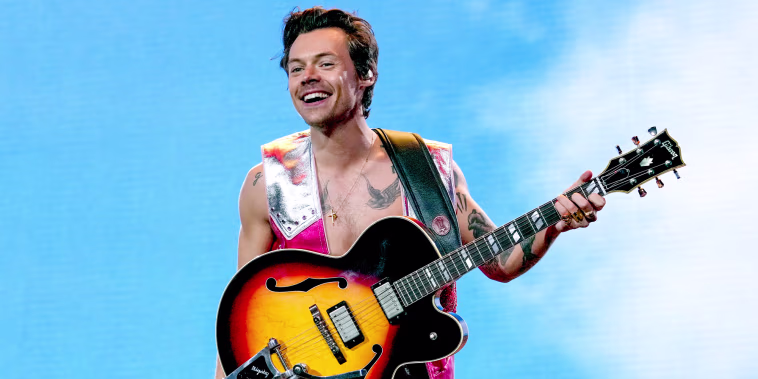 Harry Styles plays guitar on stage
