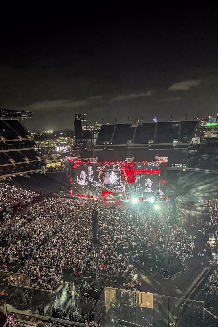 A wide shot of an outdoor stadium concert at night.