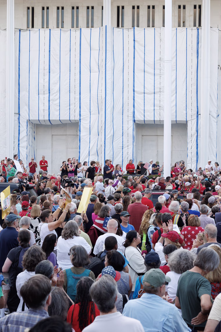 Hundreds of people gathered in front of the white stone facade of the Kennedy Center.