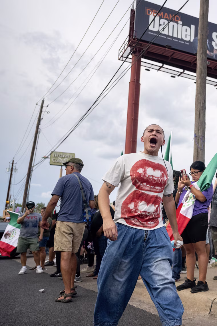People gathered for a street protest alongside a roadway.