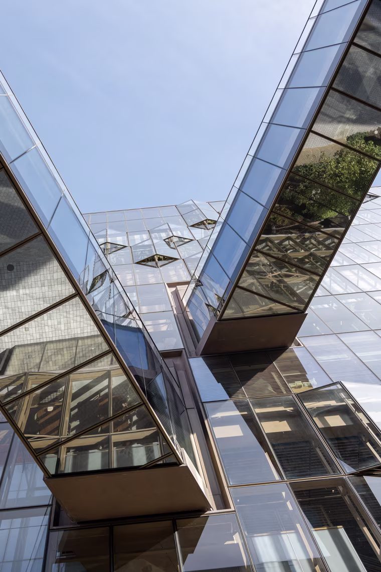 The glazed exterior of a high-rise office building with elevated walkways.