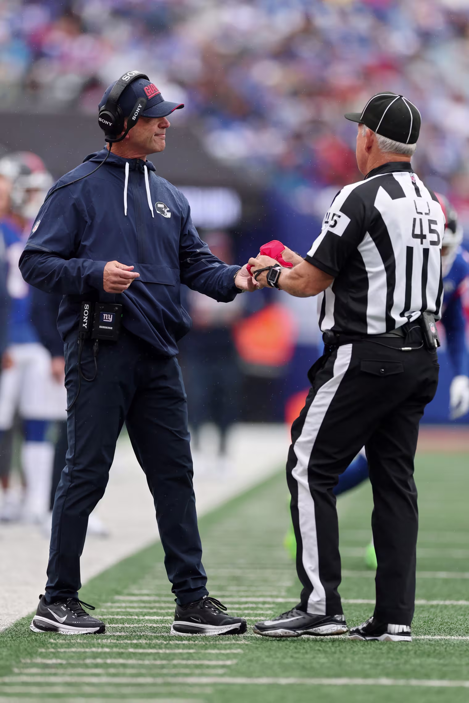 Line judge Jeff Seeman #45 returns the challenge flag to head coach John Harbaugh.
