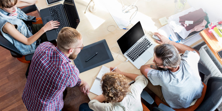 Image: People work at laptops during a meeting