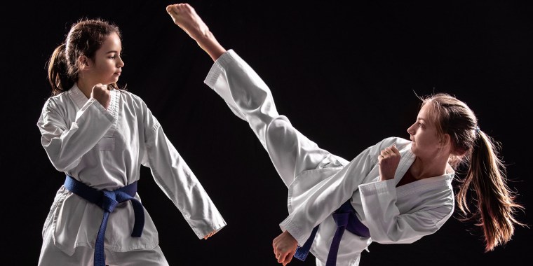 Two girls in taekwondo combat
