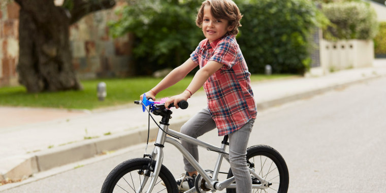 Confident boy sitting on bicycle