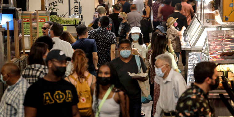 People, many masked, look for lunch at the Grand Central Market in downtown Los Angeles on June 15, 2021.