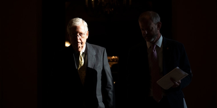 Senate Minority Leader Mitch McConnell, R-Ky., leaves his office and walks with an aide to the Senate Chamber on Aug. 4, 2021.
