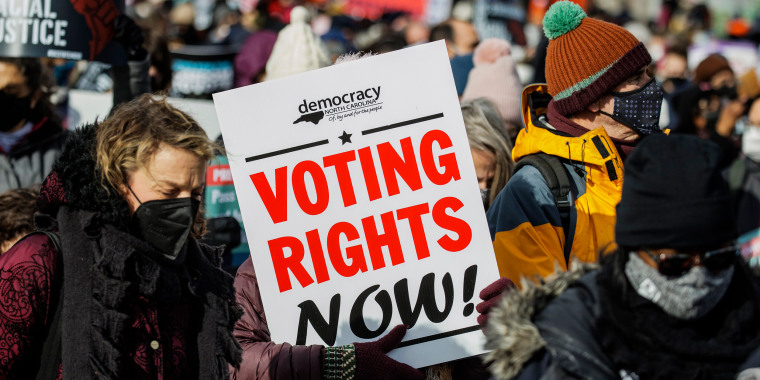 Image: People hold a sign that reads, \"Voting Rights Now\" on Jan. 17, 2022 while celebrating Martin Luther King day in Washington.