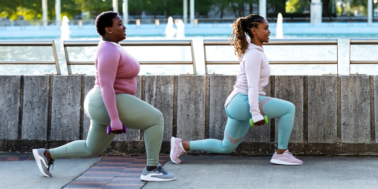 Two African-American woman doing lunges in city park