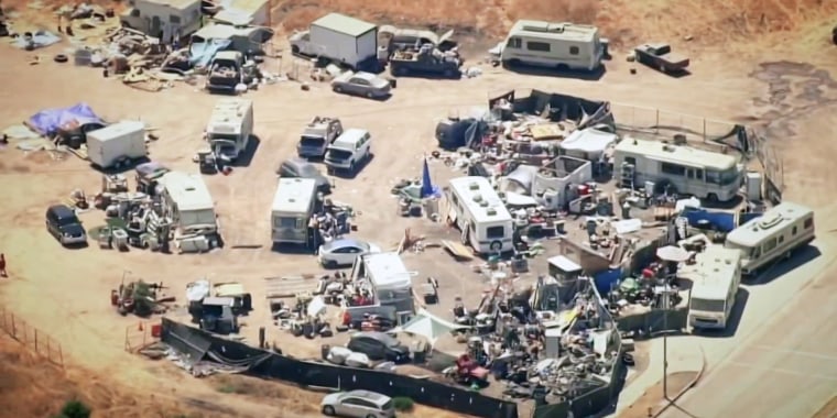 An empty San Jose lot that is owned by Apple is filled with mobile homes and makeshift wooden structures.