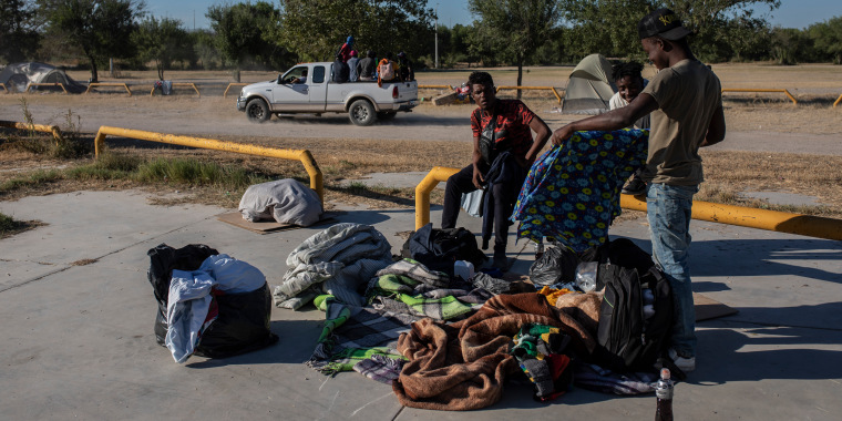 Un grupo de migrantes se aleja en la parte trasera de un camión en un campamento después de aceptar ser trasladado a un refugio, en Ciudad Acuña, México, el viernes 24 de septiembre de 2021, al otro lado del río Grande desde Del Río, Texas.