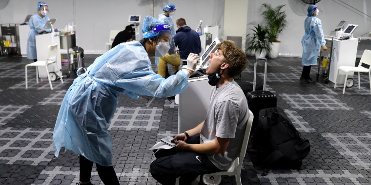 Image: A traveler receives a Covid-19 test ahead of his flight at a Histopath testing clinic at Sydney Airport in Sydney, Australia, on Dec. 7, 2021.