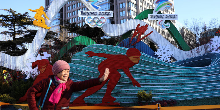 A woman poses for pictures in front of a Winter Olympics installation in Beijing on Jan. 17, 2022.