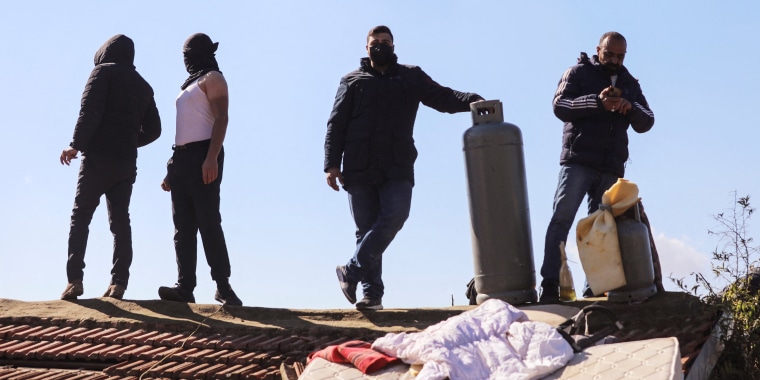 Image: Palestinians take to the roof and threaten to blow-up the building of a home in the flashpoint Sheikh Jarrah neighbourhood of East Jerusalem