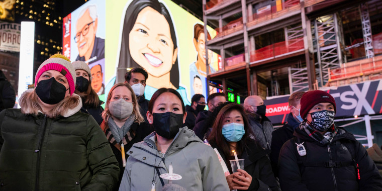 People hold candles during a vigil in honor of Michelle Alyssa Go, a victim of a subway attack, Jan. 18, 2022, in New York's Times Square.