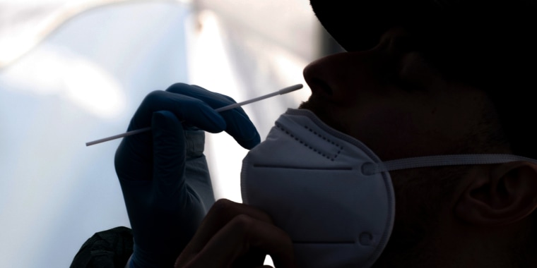 A healthcare worker administers a Covid-19 test in San Francisco on Jan. 10, 2022.