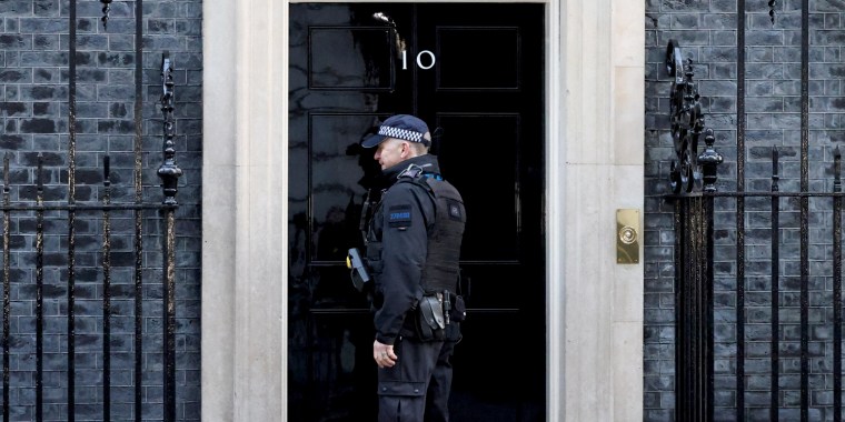 Police stand outside 10 Downing Street, in London