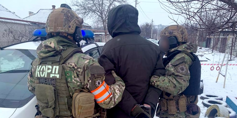 Police officers detain a man outside a munitions facility in the central Ukrainian city of Dnipro, after five were reportedly shot dead on Thursday morning.