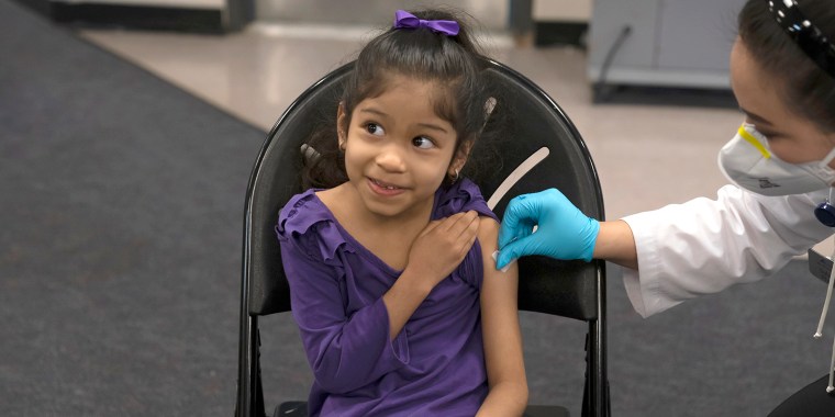 Elsa Estrada, 6, smiles at her mother as pharmacist Sylvia Uong applies an alcohol swab to her arm before administering the Pfizer COVID-19 vaccine at a pediatric vaccine clinic for children ages 5 to 11 set up at Willard Intermediate School in Santa Ana, Calif., on Nov. 9, 2021.