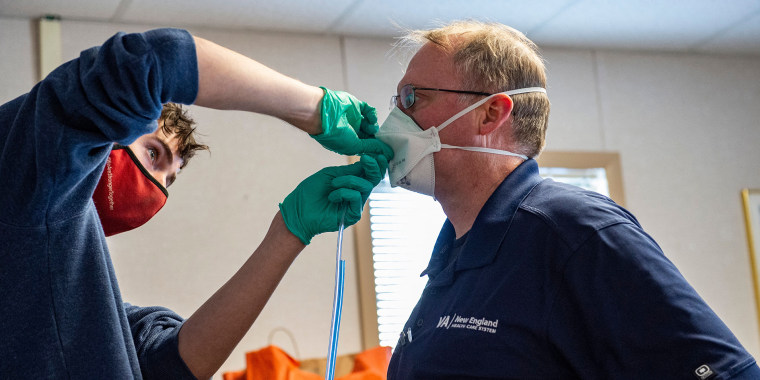 Un trabajador médico prueba una mascarilla N95 a un trabajador en un centro de salud en Massachusetts.