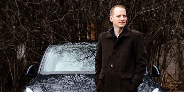Matt Smith, 35, poses with his Tesla Model Y in Farmington Hills, Mich., on March 25, 2022.