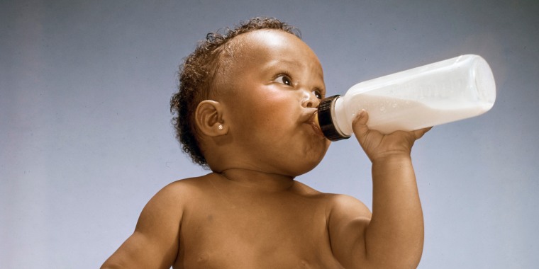 A baby drinks from a bottle circa 1975.