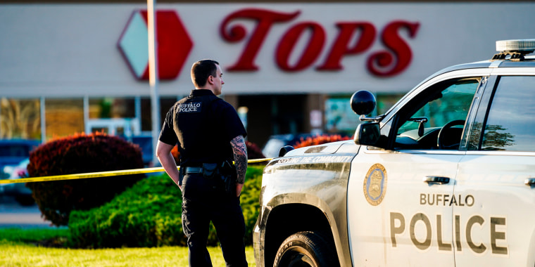 A police officer stands guard outside the scene of a shooting at a supermarket in Buffalo, N.Y., on May 15, 2022.