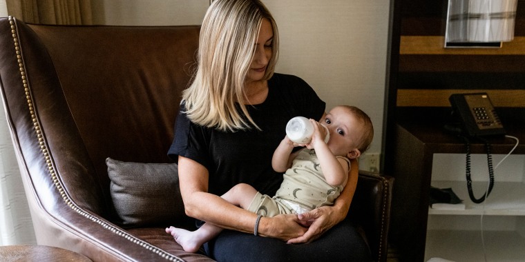 Lisa Davis, 42, holds her 14-month-old son Jack at a hotel room in Austin as he drinks a bottle of formula.