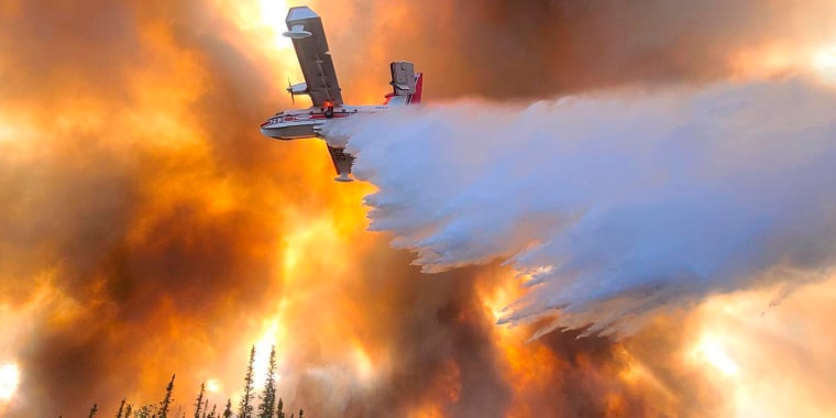 A fixed-wing aircraft drops water on the Clear Fire near Anderson, Alaska, on July 6, 2022.