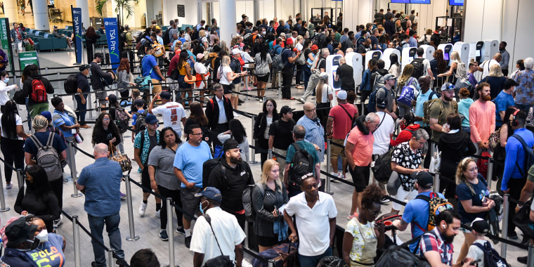 Travelers make their way through a TSA screening line at Orlando International Airport in Orlando, Fla., on July 1, 2022.