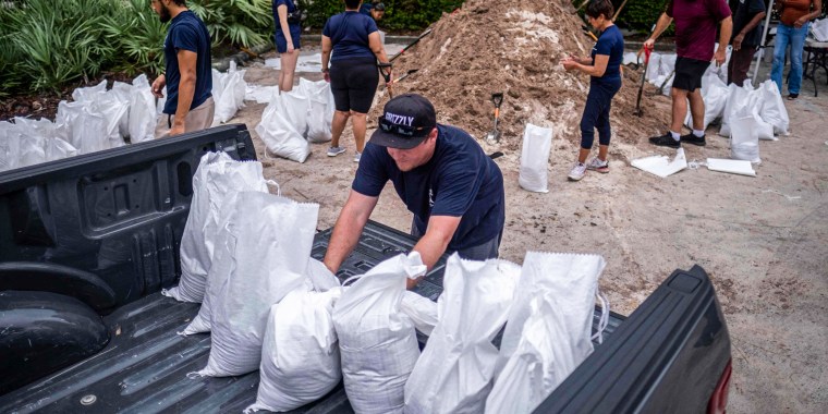 A volunteer loads sand bags into pick up truck for a customer in preparation for the arrival of Hurricane Ian in Tampa, Fla., on Sept. 27, 2022.