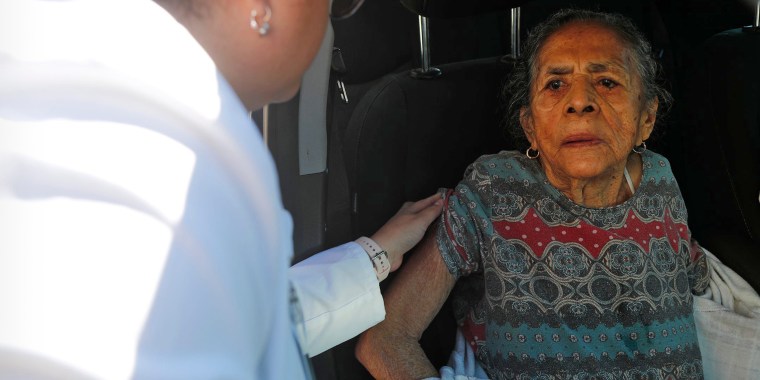 Dima Radilla, 92, receives a flu vaccination during a drive-through clinic in Garden City, Ga., on Nov. 22, 2022.