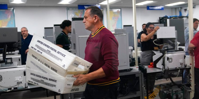 Trabajadores organizan los votos por correo que serán escaneados en el condado de Miami Dade, Florida.