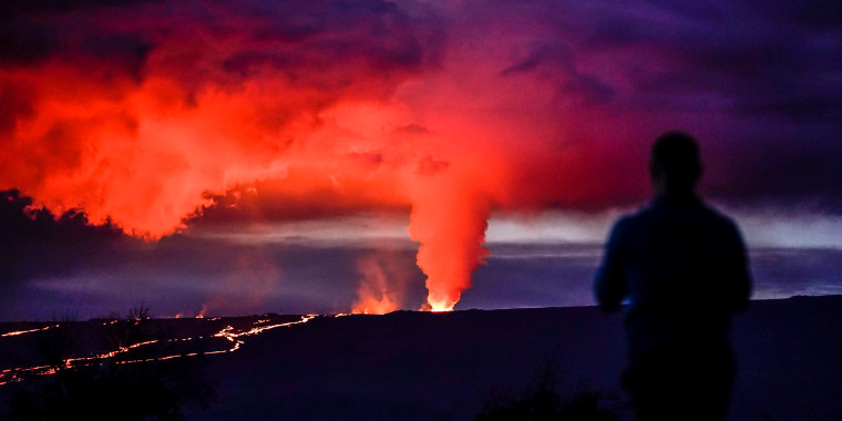 Image: A man looks on as lava erupts from Hawaii's Mauna Loa volcano on Nov. 30, 2022, near Hilo, Hawaii.