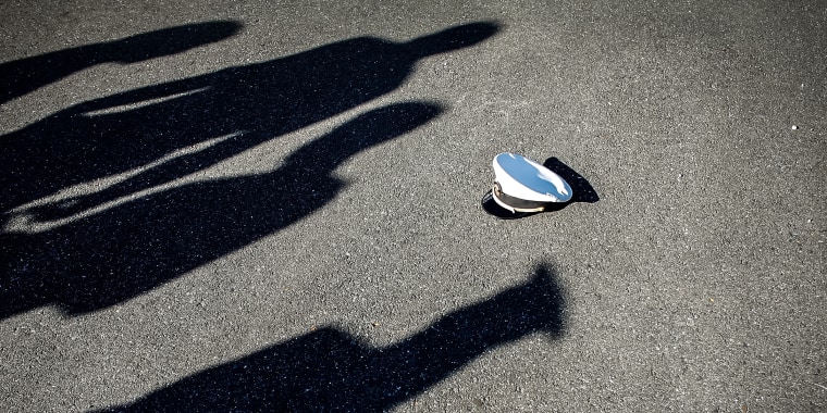 A uniform hat sits among the shadows of United States Naval Academy midshipmen graduates before the school's graduation and commissioning ceremony at the Navy-Marine Corps Stadium May 23, 2008 in Annapolis, Md.