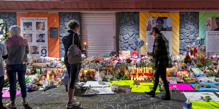 Mourners gather at a memorial for the victims of a mass shooting at Club Q