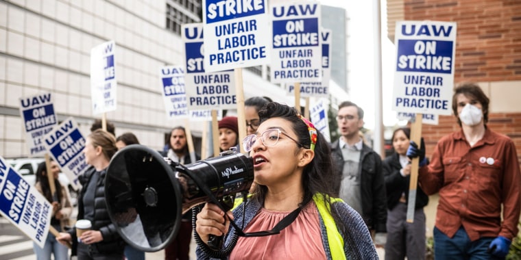 Gloria Bartolo, a 2nd year molecular biology PhD student, leads marching UCLA postdoctoral scholars and academic researchers in Westwood as they demand better wages, student housing, child care and more with University of California on Dec. 1, 2022,