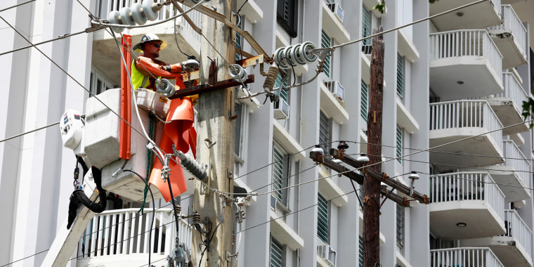 Miembros de una brigada de la empresa LUMA trabajan restaurando la energía el 20 de septiembre de 2022 en San Juan, Puerto Rico.