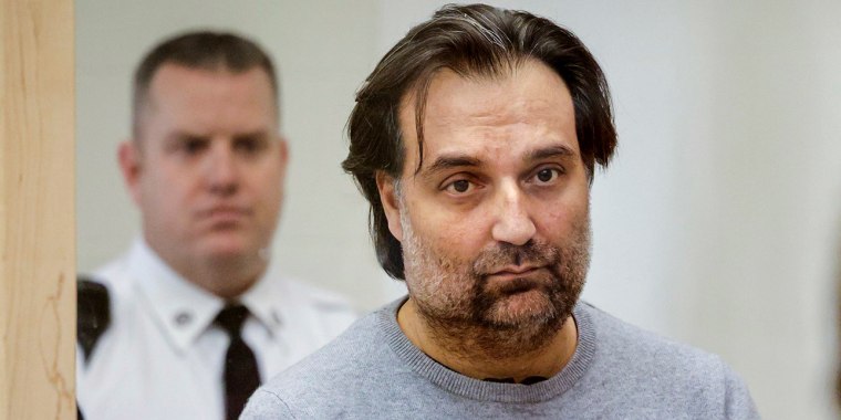 Image: Brian Walshe, center, listens during his arraignment on Jan. 18, 2023, at Quincy District Court, in Quincy, Mass., on a charge of murdering his wife Ana Walshe.