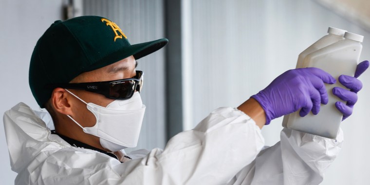 Zach Wu, a wastewater control inspector examines sewage samples that are sent to labs to analyze for any detection of the COVID-19 coronavirus in Oakland, Calif. on July 14, 2020. 