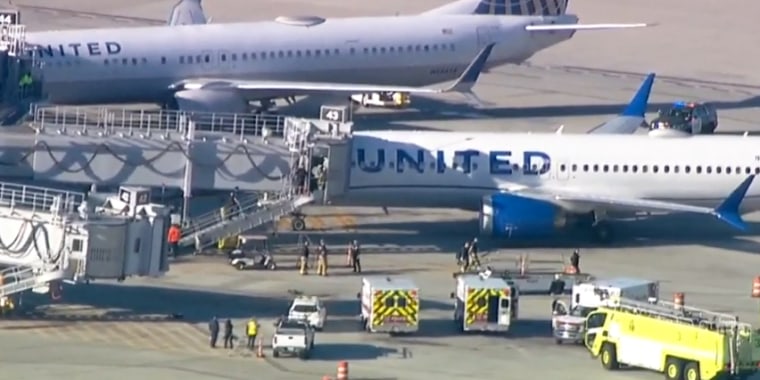 Emergency responders work near a United Airlines plane after it landed due to a fire, in San Diego, on Tuesday.
