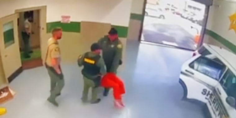 Anthony Mitchell is carried by prison guards.